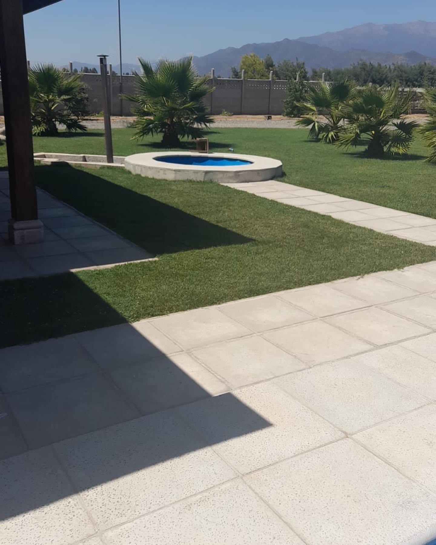 Senderos de losetas y piscina circular en jardín
